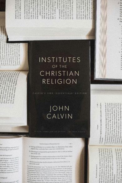 Book of christian theology surrounded by open religious texts