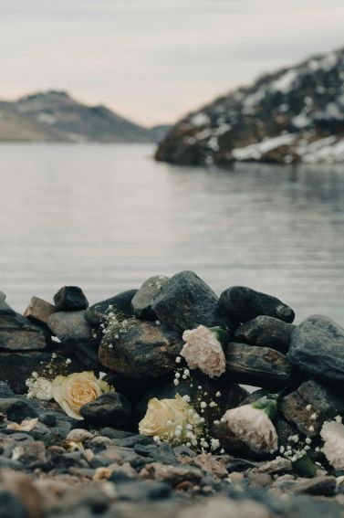 rocks and wedding flowers on a rocky beach with water in the background
